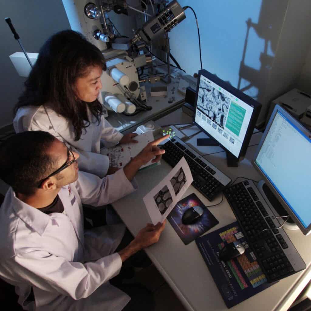 A group of scientists in a lab looking at screens doing a scientific study.