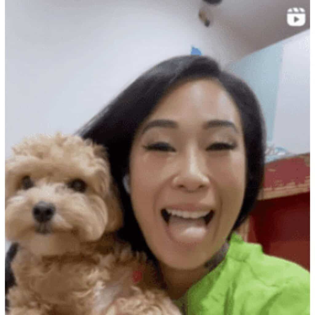 Close up of Asian woman and a small dog as a dog groomer influencer on Instagram.