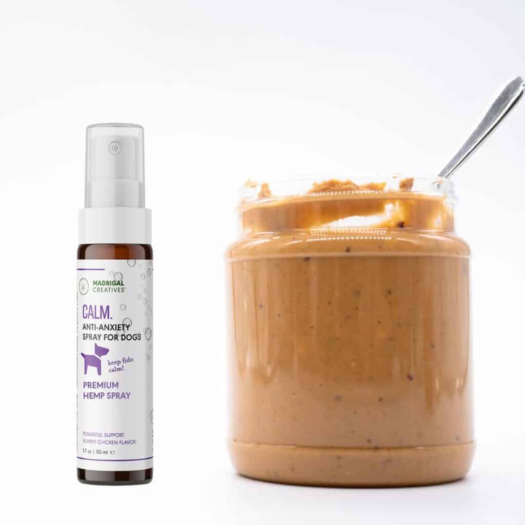 A bottle of Calm CBD spray next to a jar of peanut butter with a spoon sticking out of it on a white background.